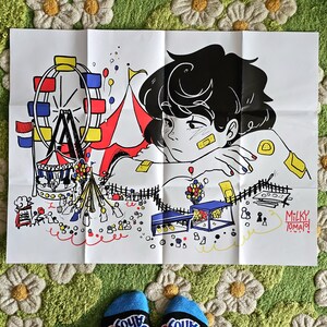 May include: A black and white illustration of a person with black hair sitting in front of a colourful carnival scene. The person is wearing a bandage on their face and has their arm resting on their lap. The carnival scene includes a Ferris wheel, a tent, and a variety of other carnival attractions. The text "MILKY TOMATO!" is written in the bottom right corner of the image.