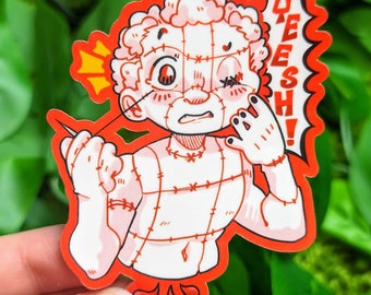 以下が含まれることがあります： 赤いと白い漫画のステッカーで、縫い付けられた人が針と糸を持っています。その人は赤い縫い付けられた口をしていて、片方の目は縫い付けられています。ステッカーには赤い吹き出しに「YEESH！」と書かれています。