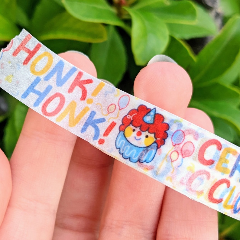May include: White washi tape with a colourful clown illustration and the text "Honk! Honk!" in a rainbow font.