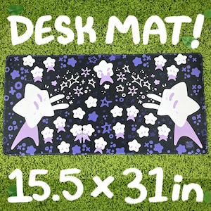 Puede incluir: Alfombrilla de escritorio negra con un patrón repetido de estrellas blancas y moradas y el texto "DESK MAT!" y "15.5 x 31 in" (aproximadamente 39,4 x 78,7 cm). La alfombrilla presenta un gran diseño de personaje de estrella a cada lado.
