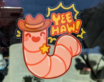 Puede incluir: Un gusano de dibujos animados rosa que lleva un sombrero de vaquero marrón con una estrella amarilla. El gusano sonríe y el texto "Yee Haw!" está por encima del gusano.