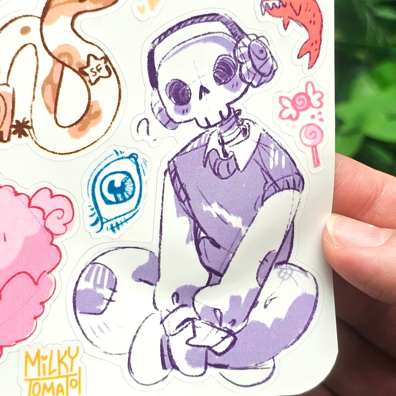 May include: A sticker featuring a cartoon skeleton wearing headphones and a purple sweater. The skeleton is sitting on a cloud with a Milky Tomato logo in the bottom left corner.