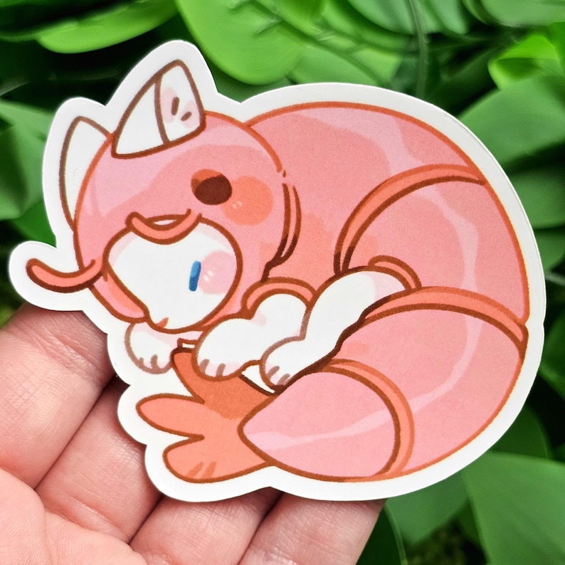 Puede incluir: Una pegatina de dibujos animados rosa y blanca de una gamba enroscada durmiendo. La gamba lleva una c&aacute;scara rosa y blanca.