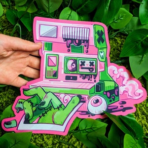 Puede incluir: Una ilustración rosa y verde de una cámara vintage con una mano verde que sale del rollo de película. La cámara tiene un objetivo verde con un solo ojo y el texto "X X" encima. La cámara está rodeada de nubes rosas y blancas.