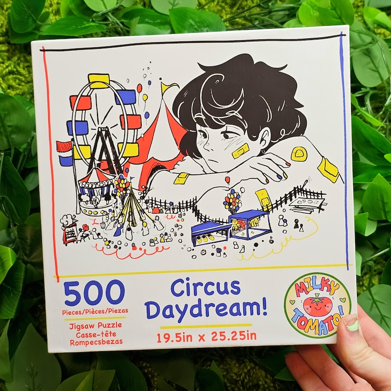 May include: A 500-piece jigsaw puzzle featuring a colourful illustration of a circus scene with a Ferris wheel, a tent, and a person daydreaming. The puzzle is titled "Circus Daydream!" and is made by Milky Tomato. The puzzle measures 49.5 cm by 64.1 cm.