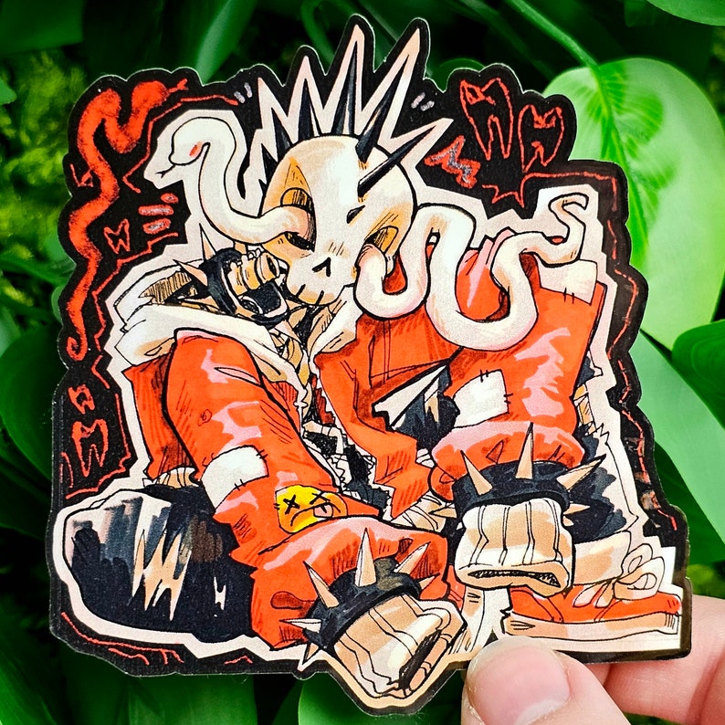 May include: A sticker featuring a cartoon illustration of a character with a skull-like head, orange clothing, and black accents. The character has spikes and is wearing a spiked bracelet. The sticker has a black border with red and white details.