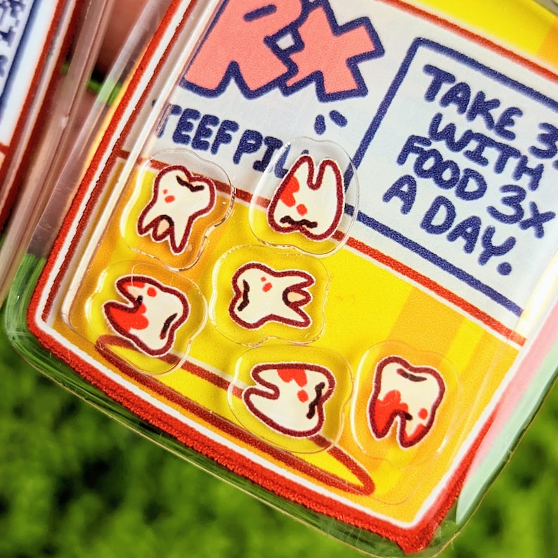 May include: A close-up of a yellow and red sticker with the text "Take 3 with food 3x a day."  The sticker has six white teeth with red accents on them.