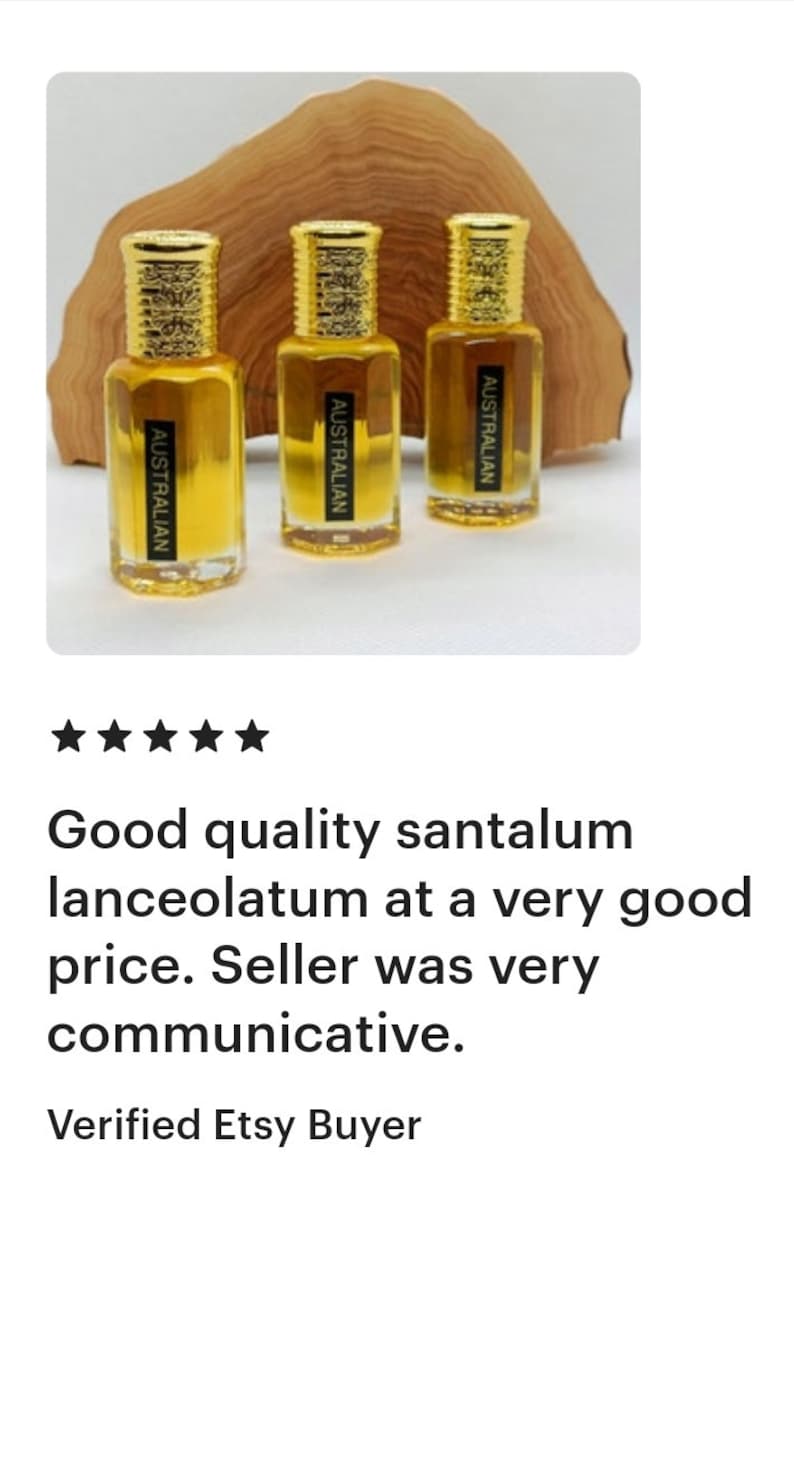 May include: Three small, clear glass bottles with gold-colored caps and labels that read "AUSTRALIAN." The bottles contain a golden liquid and are displayed in front of a wooden background.