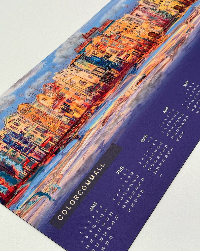 K&ouml;nnte beinhalten: Ein farbenfroher Kalender mit einem Gem&auml;lde einer Stadtlandschaft. Der Kalender ist lila mit goldenen Buchstaben und umfasst die Monate Januar bis Mai.