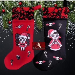 May include: Two holiday stockings, one red and one black, featuring a top cuff with a black and red paint splatter pattern. The red stocking displays a cartoon character in a Santa hat, bats, and candy canes. The black stocking shows a vampire character in a Santa hat, bats, and candy canes.
