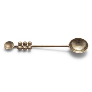 May include: A vintage-style silver spoon with a small round bowl at one end and a larger, deeper bowl at the other. The handle features a series of six small, spherical embellishments. The spoon is set against a white background.
