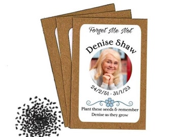 May include: A brown paper packet with a white label that says "Forget Me Not Denise Shaw 24/2/51 - 31/1/23" and has a photo of a woman. The label also says "Plant these seeds & remember Denise as they grow".