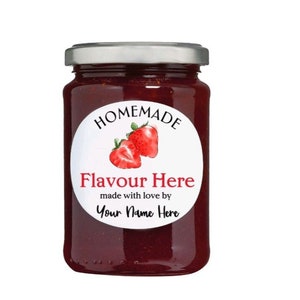 Puede incluir: Un tarro de vidrio lleno de mermelada roja casera con una etiqueta redonda blanca que dice "HOMEMADE" en texto negro, con un dibujo de dos fresas, y el texto "Flavour Here made with love by Your Name Here" en texto negro.