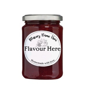 Op de afbeelding: Een glazen pot gevuld met rode jam, met een zilveren deksel. Een wit rond etiket met zwarte tekst luidt "Makers Name Here Flavour Here Homemade with love".