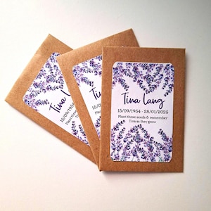 May include: Three brown paper envelopes with white labels. Each label features a watercolour illustration of lavender flowers and the text "Tina Lang" with the dates "15/09/1954 - 28/01/2025" and the text "Plant these seeds & remember Tina as they grow."