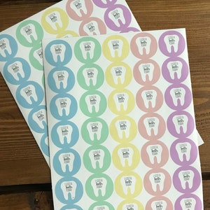 May include: Sheets of colorful stickers with a tooth graphic and the text "I lost a tooth today." The stickers are round and come in pastel colors including pink, yellow, blue, green, and purple. Great for kids.