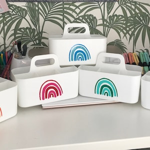 May include: Five white plastic storage bins with handles. Each bin features a rainbow design in different colour combinations. The rainbows are in shades of orange, red, blue, green, and purple.