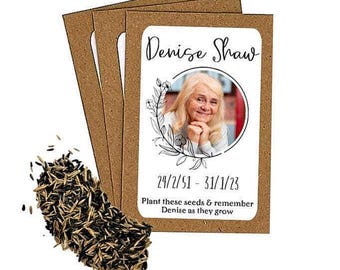 May include: Seed packets with a photo of a woman, the name "Denise Shaw", and dates. The packets are brown with a white label. Text reads "Plant these seeds & remember Denise as they grow". A pile of seeds is in the foreground.