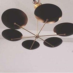 A low-angle shot of the black and brass sputnik chandelier mounted on a white ceiling.