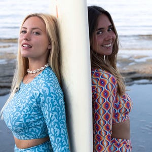 Women’s sustainable high-waist swim shorts with turquoise coral print, perfect for surfing and beach activities. Made from eco-friendly recycled fabric, offering UV protection and a comfortable, retro-inspired fit.