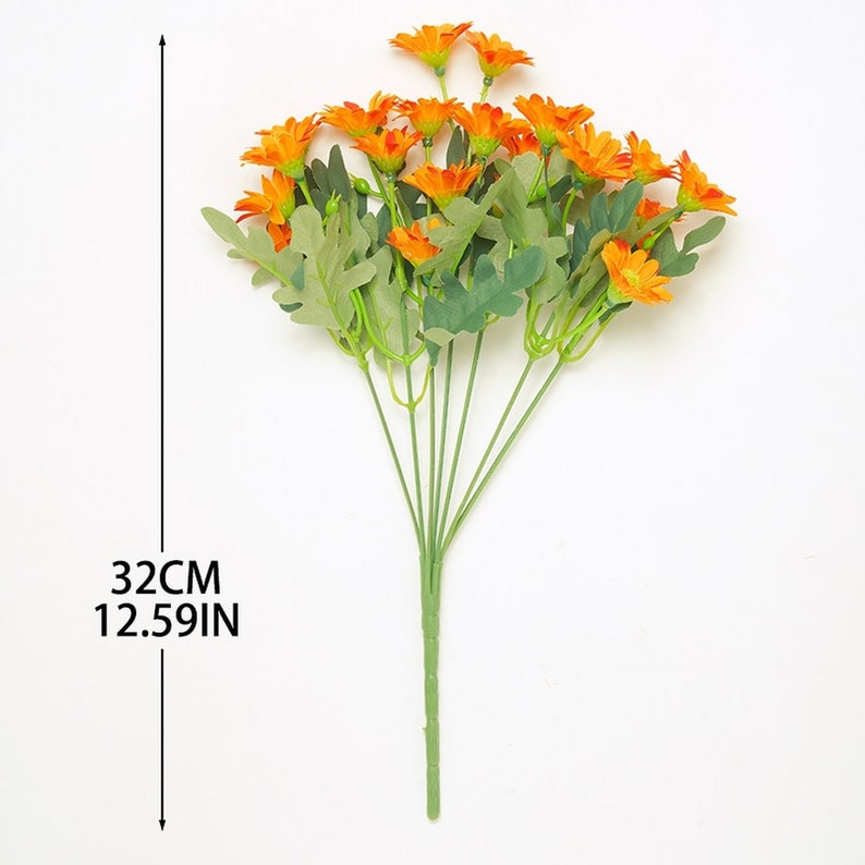 Puede incluir: Un ramo de 18 flores artificiales de color naranja con hojas verdes. Los tallos son verdes y miden 32 cm de largo.