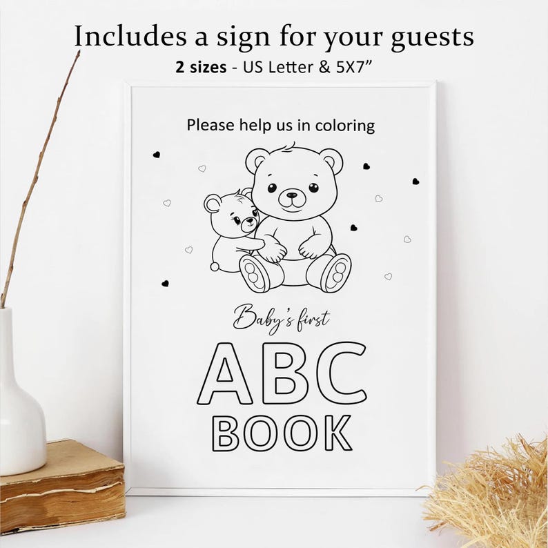 May include: A white framed sign with the text "Includes a sign for your guests" and "Please help us in coloring". The sign features a black and white illustration of two teddy bears and the words "Baby's first ABC BOOK".