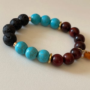Raquel | Turquoise Gemstone | Burgundy Wood | Black Lava | Platted Gold Spacer | Tassel | Diffuser Bracalet
