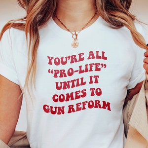 May include: White t-shirt with red text that reads "You're all "Pro-Life" until it comes to gun reform."