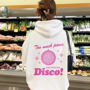 May include: White hoodie with a pink graphic of a disco ball and the text "Too much panic, Not enough Disco!"