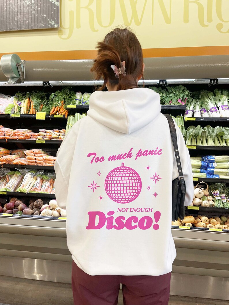 May include: White hoodie with a pink graphic of a disco ball and the text "Too much panic, Not enough Disco!"