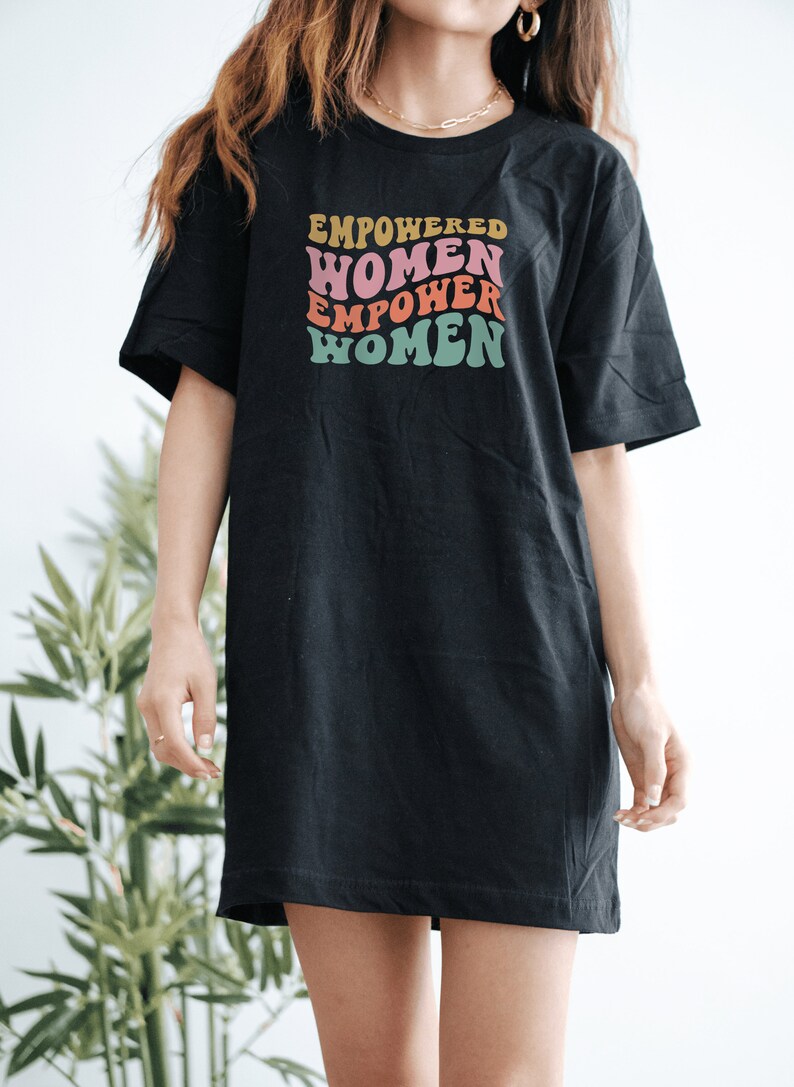 May include: Black oversized t-shirt with a retro-style graphic that reads "EMPOWERED WOMEN EMPOWER WOMEN" in pink, orange, yellow, and green.