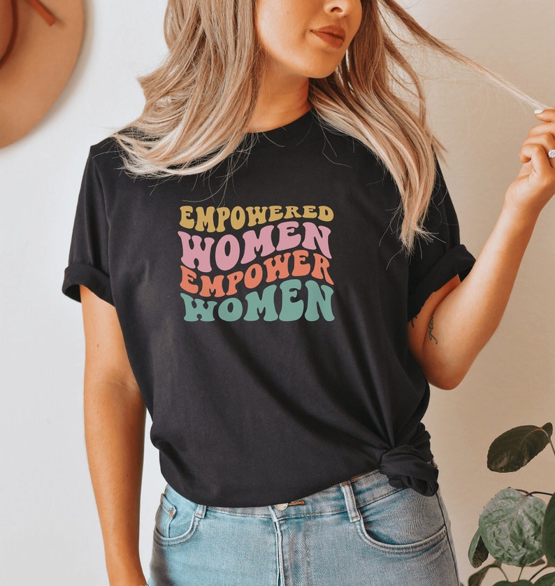 May include: A black t-shirt with a colorful graphic that reads "Empowered Women Empower Women".