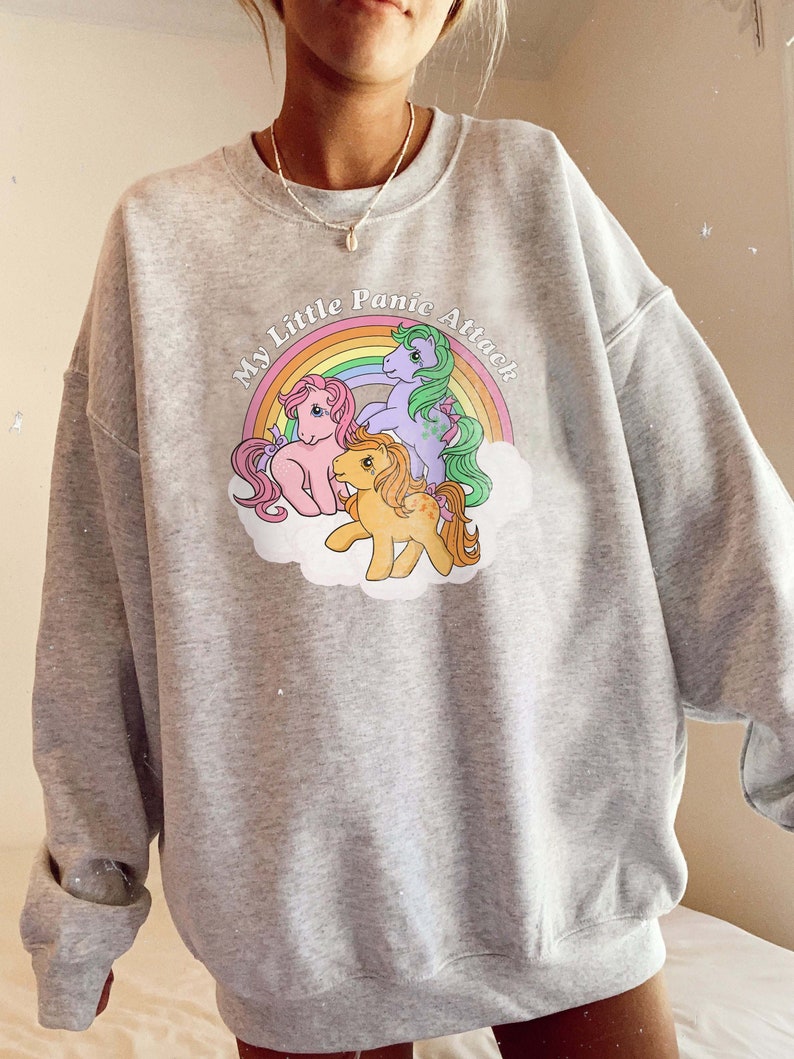 May include: Gray sweatshirt with a graphic of three My Little Pony characters with a rainbow and the text "My Little Panic Attack".