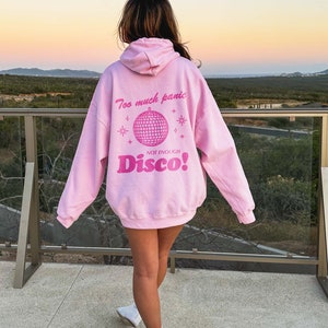 May include: Pink hoodie with a graphic of a disco ball and the text "Too much panic not enough Disco!"