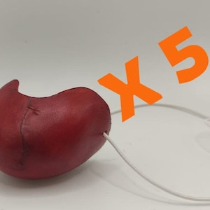 May include: Five red leather boxing gloves with white laces. The gloves are tied together with a white string.