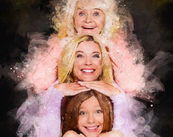 May include: Three generations of women smiling at the camera. The oldest woman is wearing a pink shirt and has her hands on the shoulders of the middle woman. The middle woman is wearing a purple shirt and has her hands on the shoulders of the youngest woman. The youngest woman is wearing a blue shirt and has her hands on her chin.