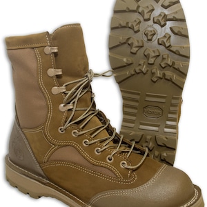 May include: Tan leather military boots with a Vibram sole. The boots have a lace-up closure and a brown mesh panel on the side.