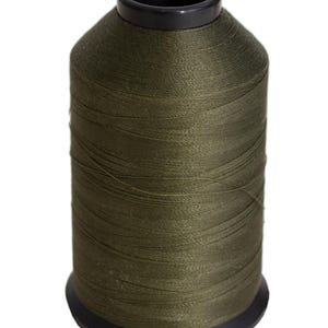 May include: A spool of olive green thread on a black plastic bobbin.