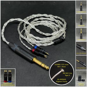 Może przedstawiać: Srebrny i przezroczysty kabel audio z pozłacanym wtykiem 6,35 mm i czarnym wtykiem. Kabel jest oznaczony tekstem "22AWG 133 cores OD 1.4mm 7N OCC Litz Type 2 99.9999x% Highest Purity".