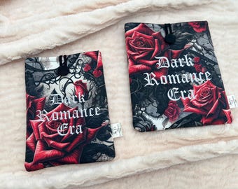 May include: Two rectangular book sleeves with a dark floral design. The sleeves feature large red roses, black lace patterns, and the text "Dark Romance Era" in white gothic lettering. Each sleeve has a black button closure.