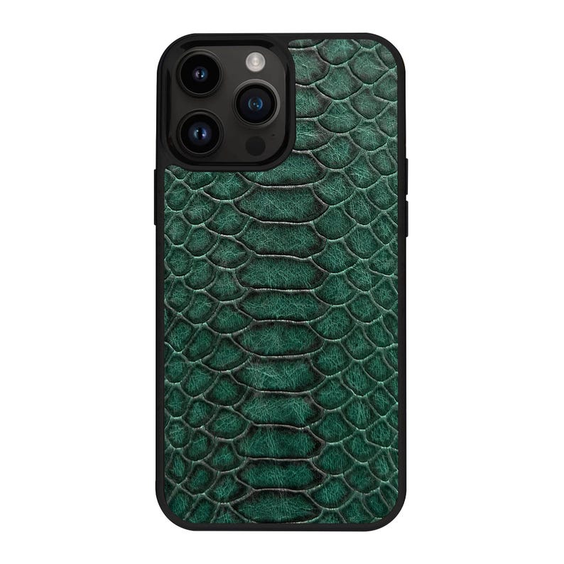 Op de afbeelding: Een smartphonehoesje met een getextureerd, diep smaragdgroen slangenleerpatroon. Het hoesje heeft een zwarte rand en een uitsparing voor een camerasysteem met drie lenzen aan de linkerbovenkant, voorzien van een gedetailleerd schubbenpatroon.