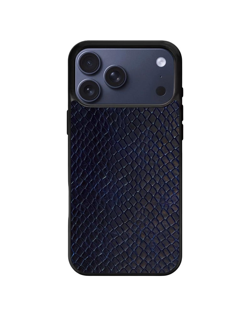 Pode incluir: Uma capa de telefone azul marinho com um padr&atilde;o texturizado de pele de cobra. A capa tem uma borda preta e um m&oacute;dulo de c&acirc;mera azul escuro com tr&ecirc;s lentes e um flash. A capa foi projetada para proteger o telefone.