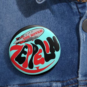 Op de afbeelding: Een witte keramische mok met een zwarte handgreep en de tekst "But First, Coffee" in een vetgedrukte, zwarte letter. De mok staat tegen een vage achtergrond, wat een gezellige setting suggereert.