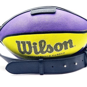 Peut inclure: Un sac à bandoulière en forme de ballon de basket violet et jaune avec une bandoulière noire et le mot "Wilson" imprimé sur le côté.