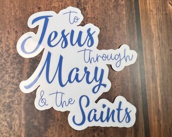 Puede incluir: Pegatina blanca con texto azul que dice "To Jesus Through Mary & The Saints".