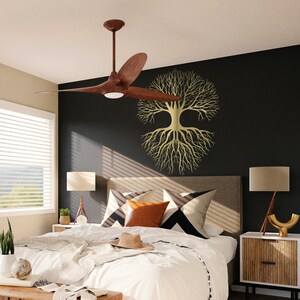 May include: A bedroom scene featuring a brown ceiling fan with three blades and a central light. The room has a black accent wall with a gold tree of life wall art. The bed has white bedding and decorative pillows.