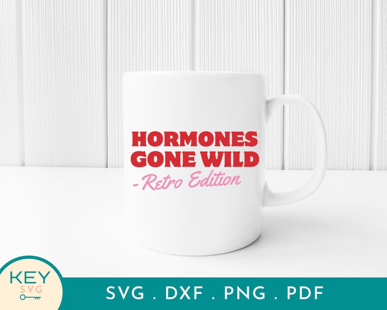 May include: A white ceramic mug with the text "HORMONES GONE WILD - Retro Edition" in red and pink lettering. The mug has a standard handle and is set against a white background.