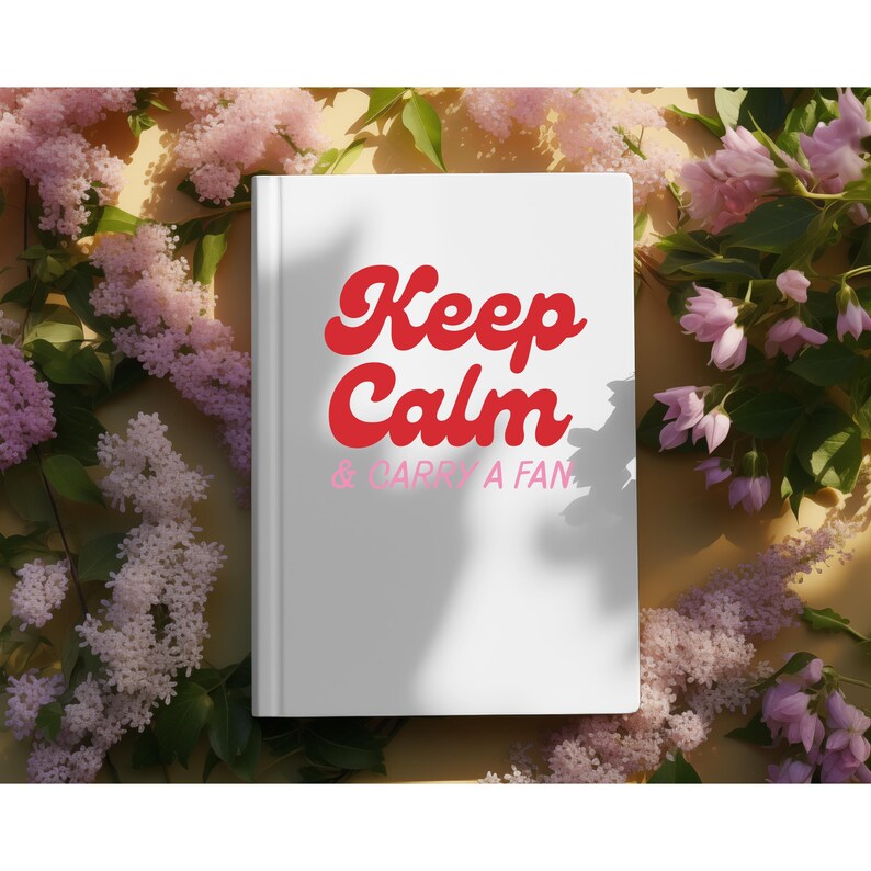 May include: A white book with the words "Keep Calm & Carry a Fan" in red and pink script. The book is surrounded by pink and purple flowers, creating a soft, floral background.