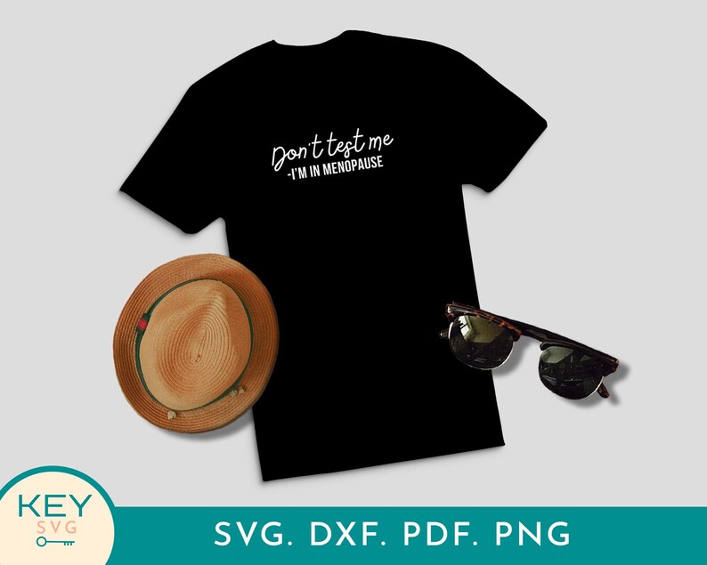 May include: Black t-shirt with the text "Don't test me - I'm in menopause" in white script. A straw hat with a green band and sunglasses are next to the shirt. The image also includes the text "SVG. DXF. PDF. PNG".
