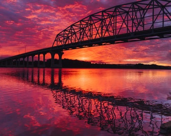 Steel Truss Bridge Silhouetted by Colorful Sunset Clouds